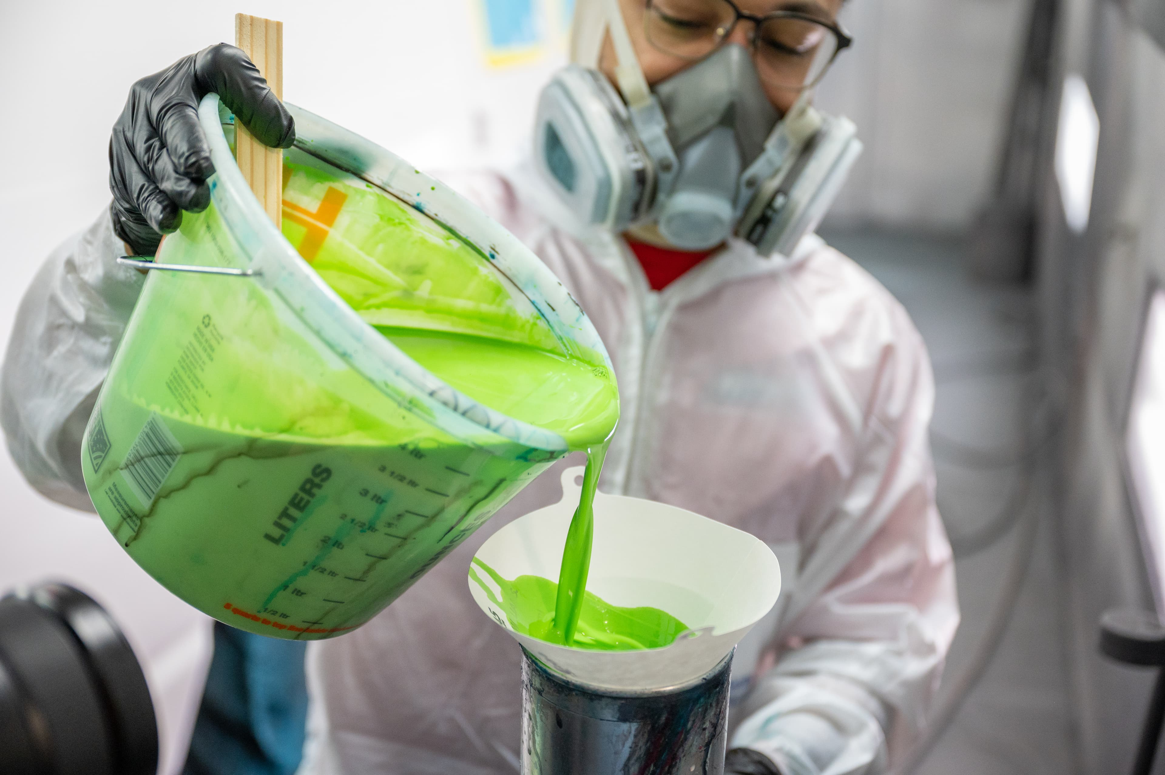 Maaco technician preparing paint for auto body painting service.